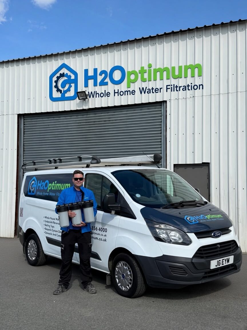 Jordan Molyneux, founder of H2Optimum, holding water filtration components beside the H2Optimum van